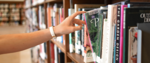 hand reaching out for book at library